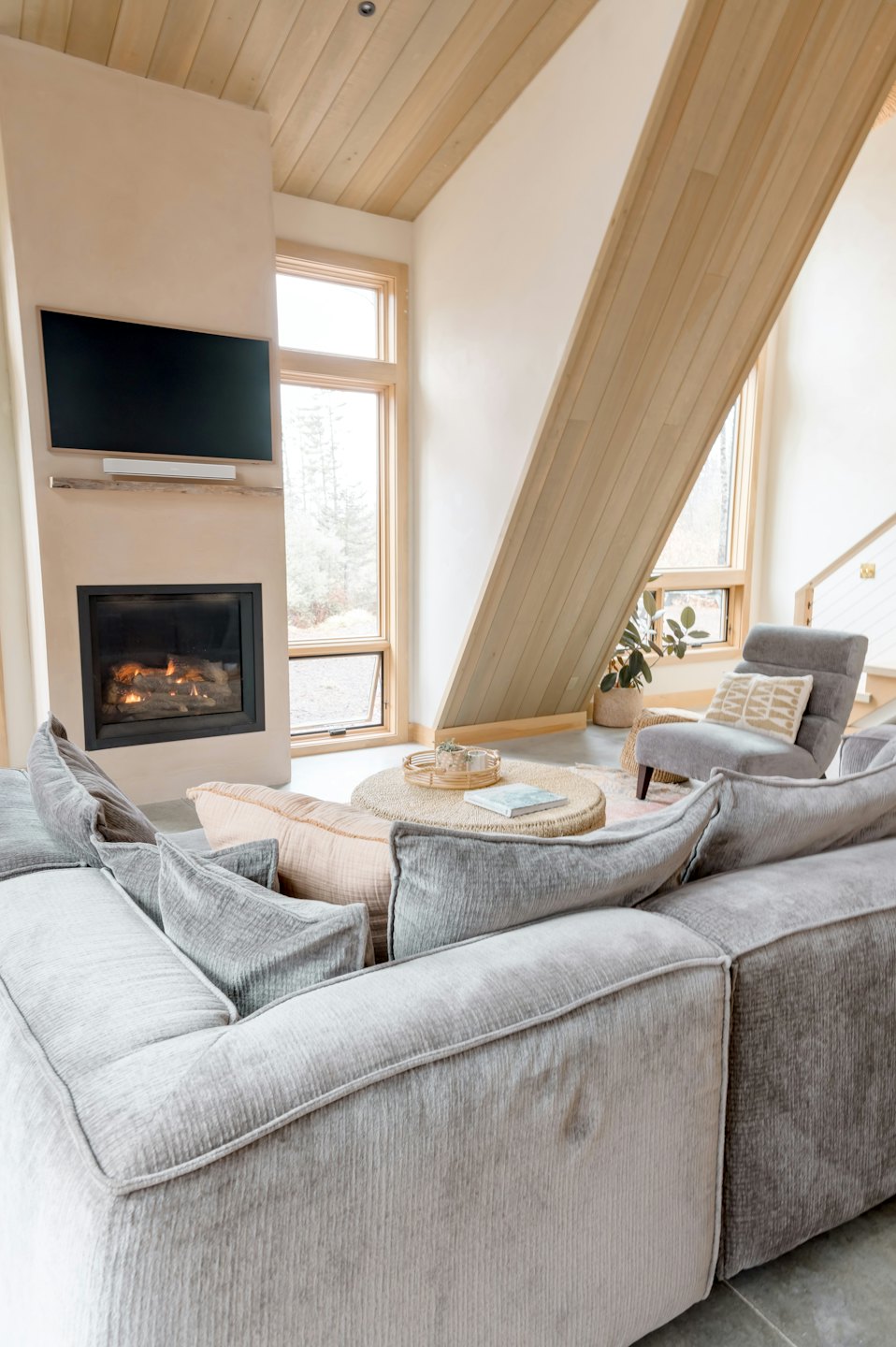 Modernes Wohnzimmer mit L-förmigem Sofa und Gaskamin.