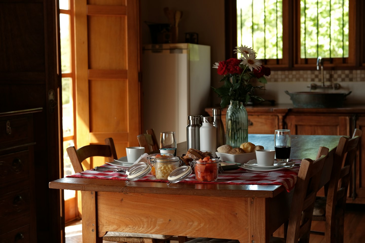 Frühstück auf karierter Tischdecke an rustikalem Tisch.