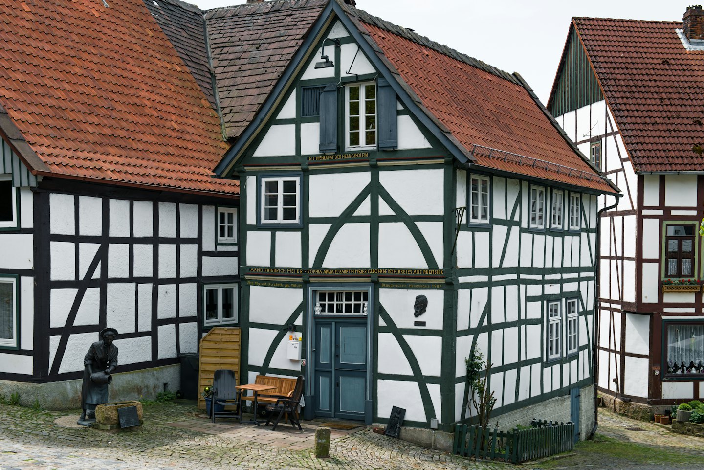 Traditionelle deutsche Fachwerkhäuser mit einer Statue auf einer Straße.
