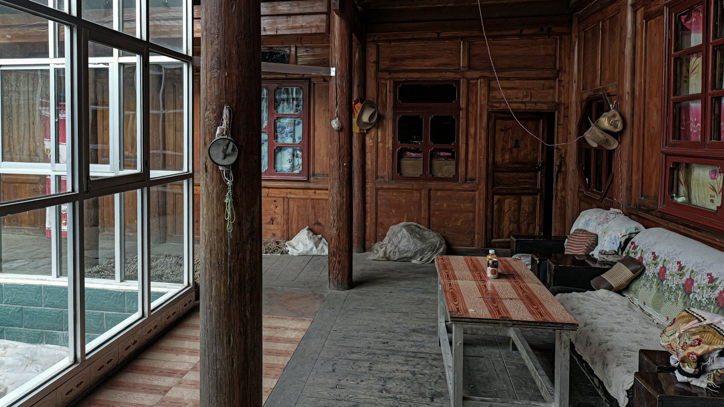 Rustikales Holzzimmer mit gemustertem Tisch und floralem Sofa.