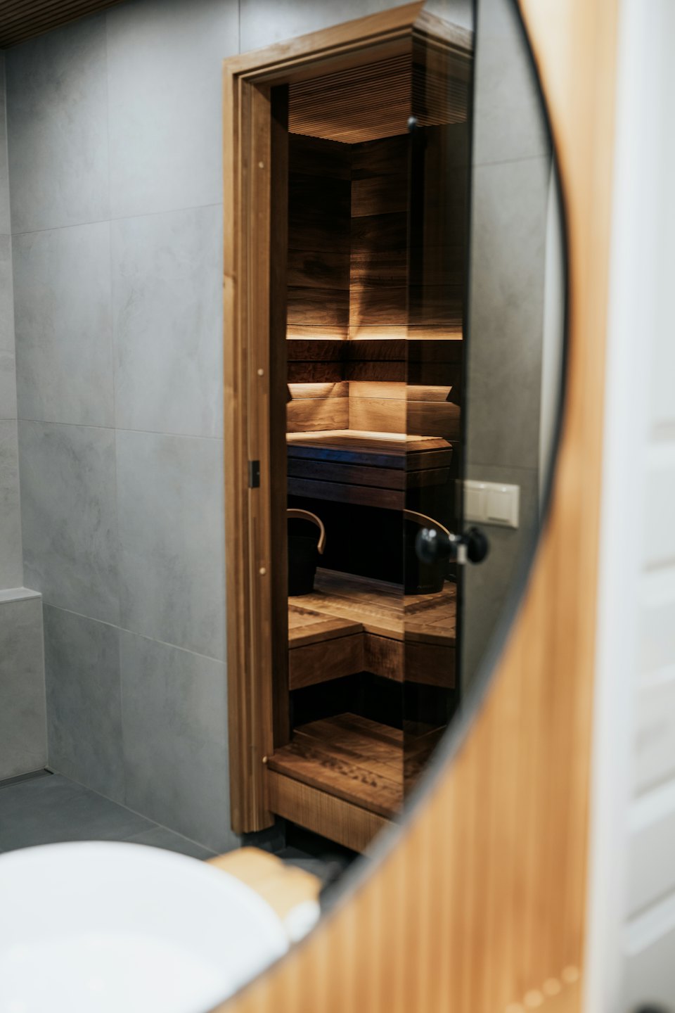 Moderne Sauna durch eine Glastür in einem Badezimmer.